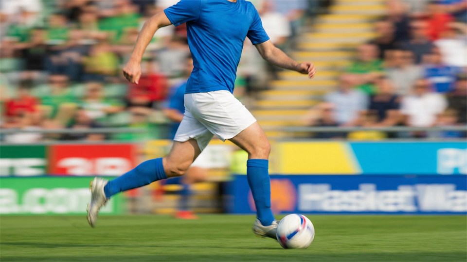 Un mediocampista box-to-box corre con el balón en el centro del campo